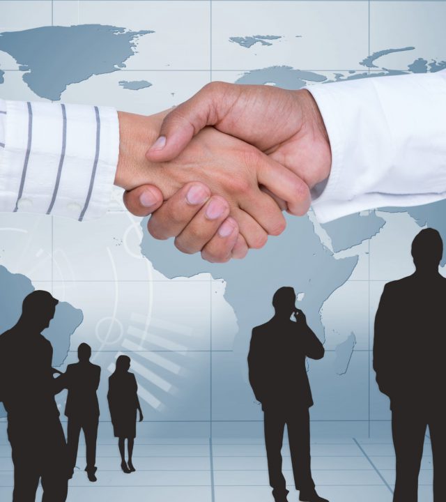 Digital composite image of businesspeople shaking hands against map background